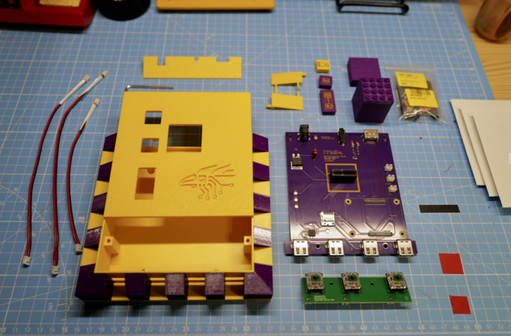 Disassembled Rook MK1 console with case, PCB, buttons, and LEGO parts on a work mat.